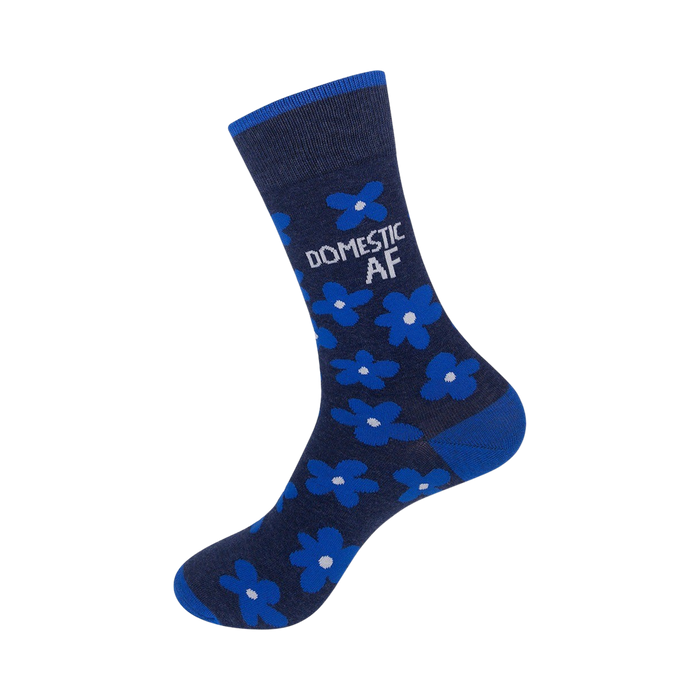Close-up view of a navy blue crew sock showcasing the bright blue flower pattern and 'DOMESTIC AF' text.