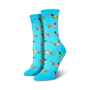 Pair of women's crew socks; light teal background with repeating pattern of brown dachshunds wearing colorful sweaters.