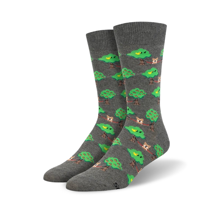 Pair of grey crew socks with a repeating pattern of dogs lounging on branches between green apple trees, and small yellow birds. }}
