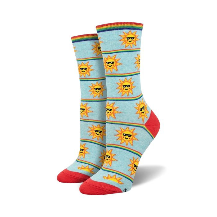 Pair of women's crew socks in light blue.  Features a pattern of smiling suns wearing sunglasses and rainbow stripes. }}