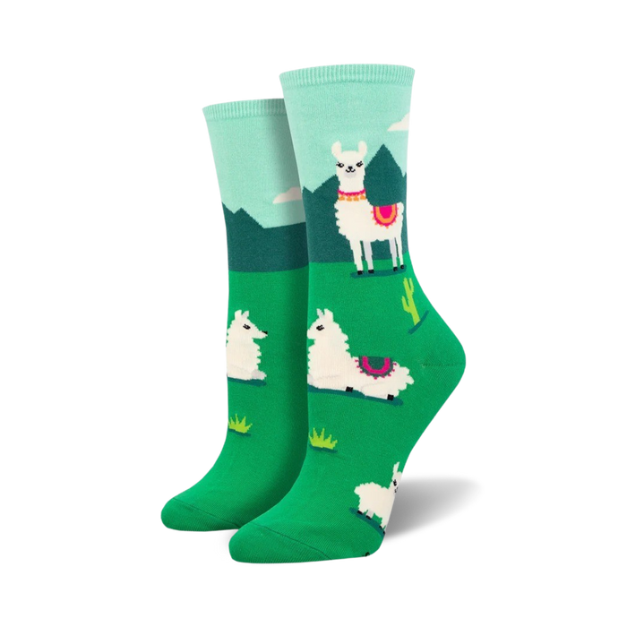 white crew socks with pink and black detailed llamas standing in a green field with cacti and mountains in the background.    }}