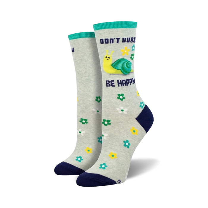 A pair of crew socks in grey with a teal cuff. The socks feature a yellow snail, flowers, and the text 'Don't Hurry, Be Happy'. }}