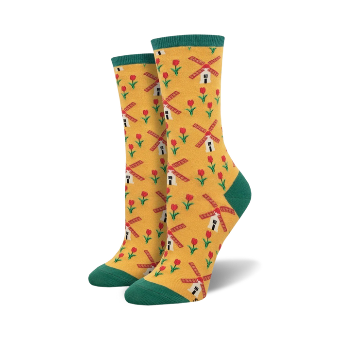A pair of women's crew socks in yellow with a pattern of red tulips and windmills. The socks have teal green cuffs. }}