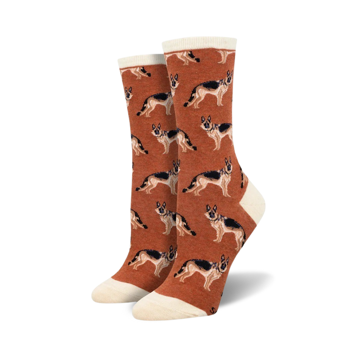A pair of rust-colored crew socks with a repeating German Shepherd pattern. The socks have a cream-colored cuff.