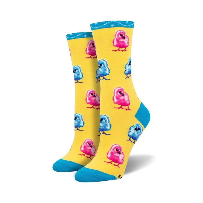 Pair of crew socks featuring a pattern of pink and blue chicks on a yellow background. Teal cuff detail.