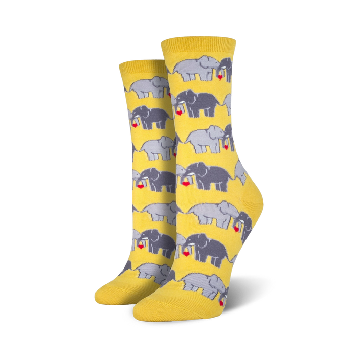 Pair of women's crew socks in yellow and grey, featuring a repeating pattern of elephants playfully holding hearts.