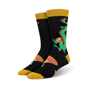 Close-up of black crew socks with a gold cuff, showcasing a detailed dragon and fan design.