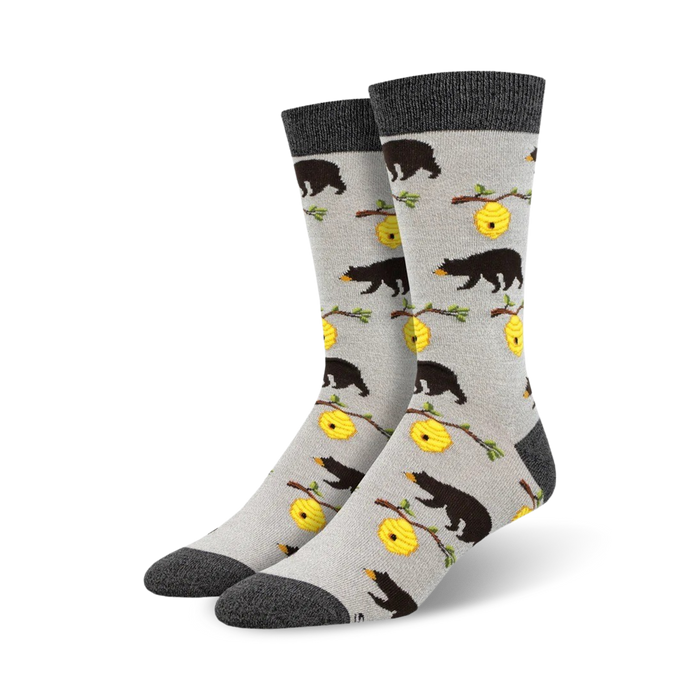 Pair of crew socks in grey and featuring black bears and yellow honeycombs on a light grey background.
