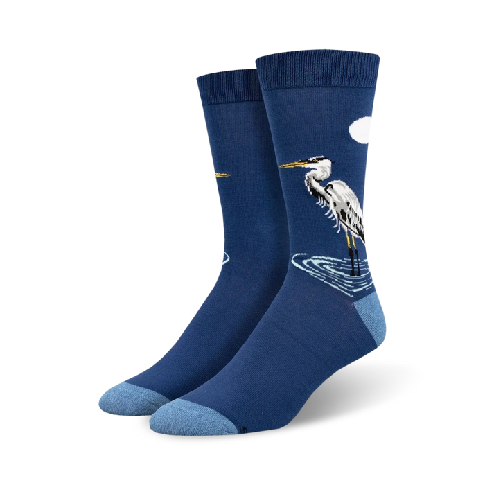 Pair of navy blue crew socks featuring a detailed illustration of a Great Egret standing in water, with a small white cloud in the upper right corner. }}