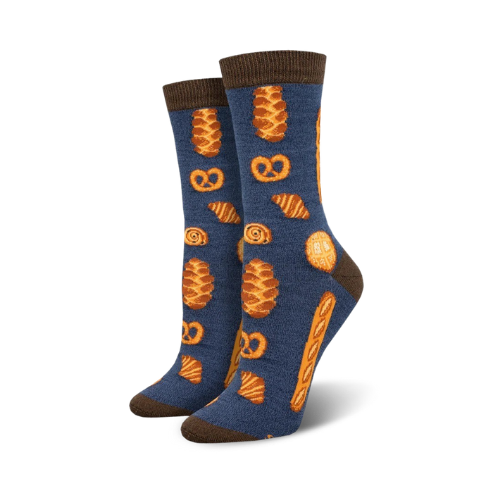 Pair of women's crew socks.  Navy blue with brown-topped cuff. Features repeating pattern of pretzels, croissants, and other baked goods in orange-gold. }}