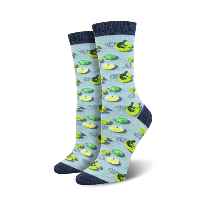 A pair of light blue crew socks with a pattern of green frogs on yellow lily pads.  The socks have a navy blue cuff. }}