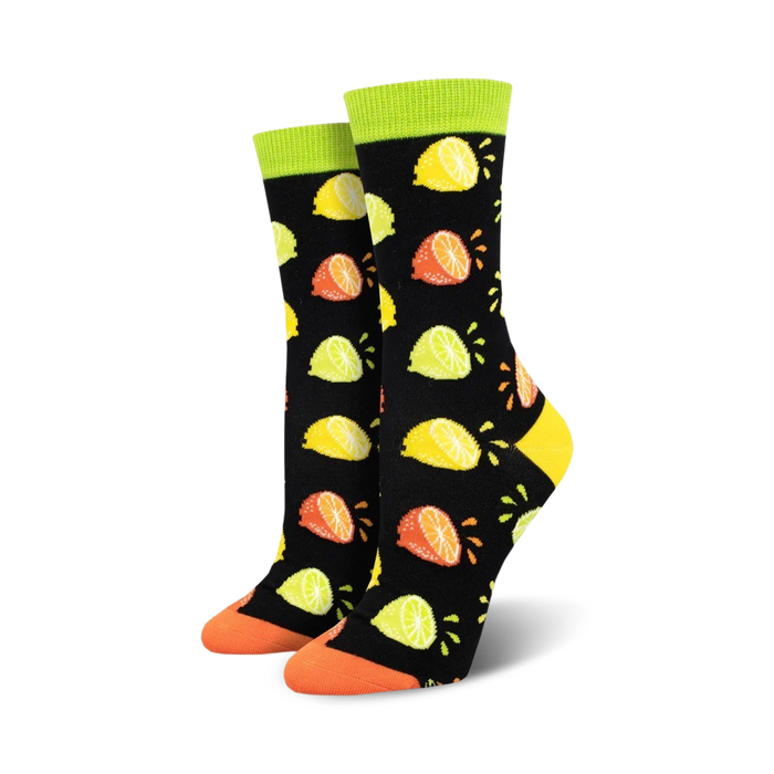 Pair of women's crew socks with a black background and a pattern of colorful lemons, limes, and oranges. Lime green cuffs and orange toes. }}