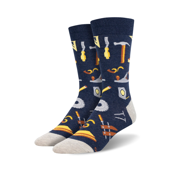 Pair of navy blue crew socks with a pattern of various tools, including hammers, saws, and measuring tools, in yellow and brown. }}
