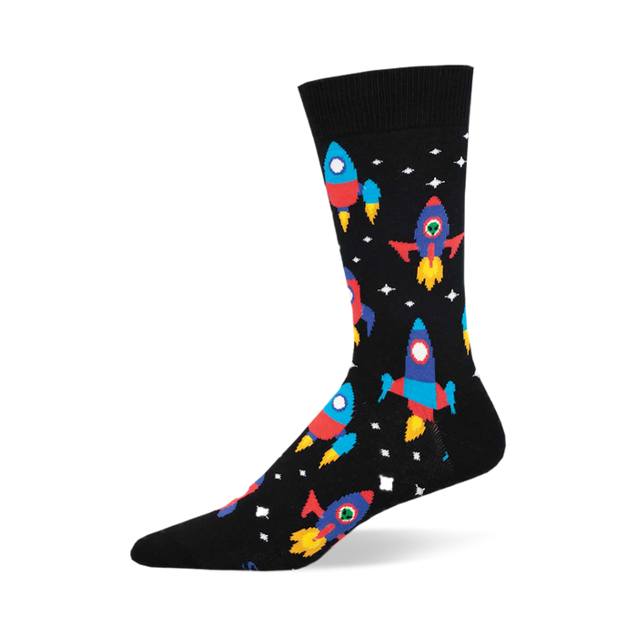 the black socks have a pattern of rockets. the rockets are red, blue, yellow, and green with portholes. there are also white stars and yellow and orange planets. }}