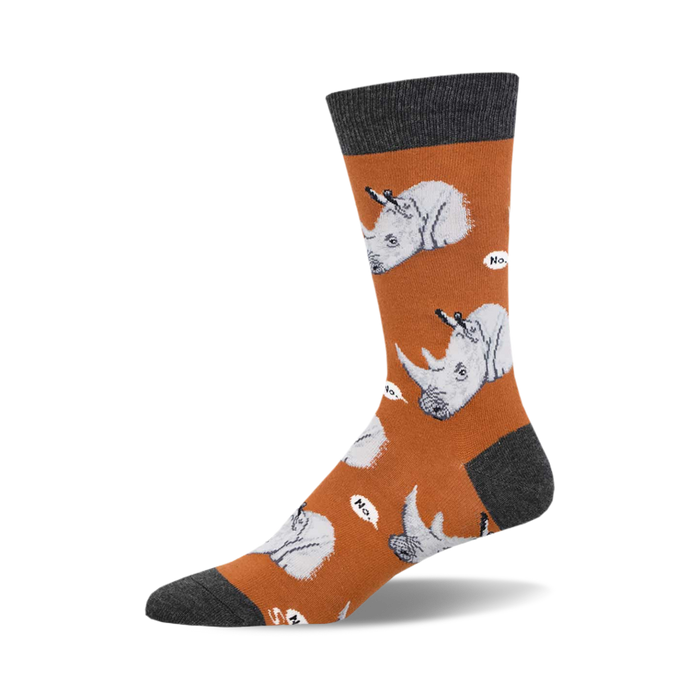 socks that are orange with gray toes, heels, and cuffs. socks with a pattern of cartoonish rhinos wearing party hats and holding a knife and fork. the rhinos are on a white cloud and have speech bubbles that say 