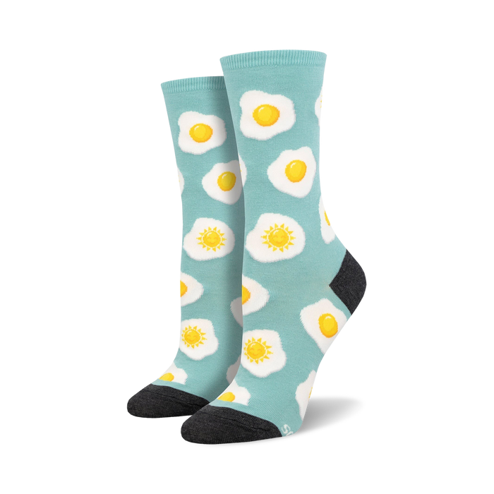 Pair of teal crew socks with a repeating pattern of sunny-side up fried eggs. Yellow yolks and white egg whites on a light teal background. Dark grey heel and toe. }}