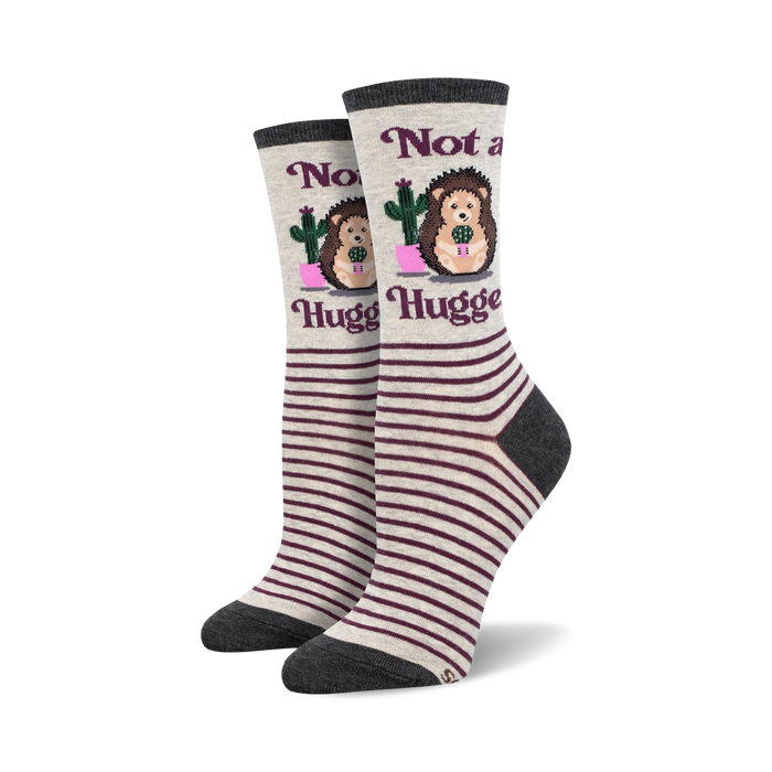 Pair of women's crew socks. Grey and burgundy stripes. Features a hedgehog holding a cactus and the text 'Not a Hugger'. }}