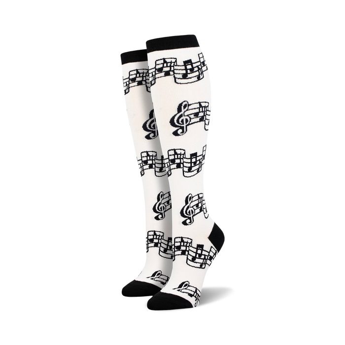 Pair of black and white knee-high socks with a musical notes and clef design.