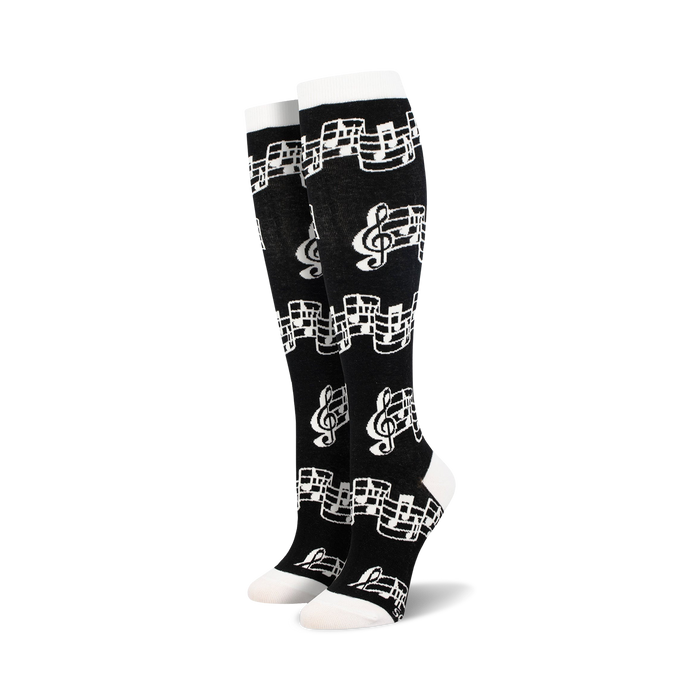 Close-up of black knee-high socks with musical notes pattern.