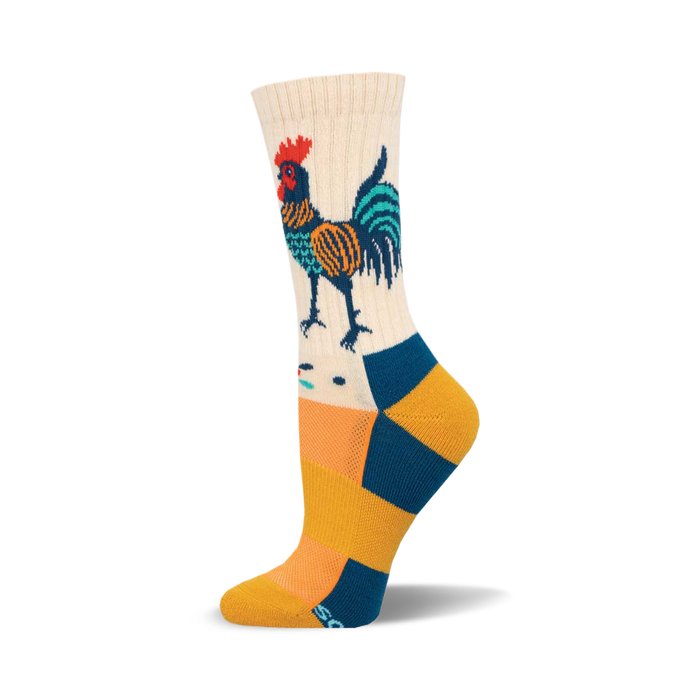 Cream crew socks with a folk art-style rooster in teal, orange, and navy. The foot features teal and gold stripes. }}