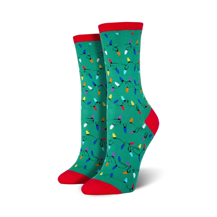 Lifestyle shot of a person wearing red Christmas Lights socks, sitting near a Christmas tree.