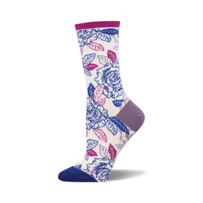 A pair of cream crew socks adorned with a vibrant print of purple and blue roses and leaves. The socks have purple and blue accents at the heel and toe. }}