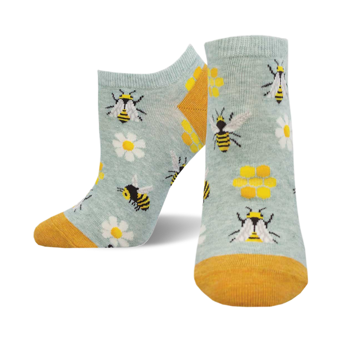 A pair of light blue ankle socks with a fun bee design. Yellow bees, daisies, and honeycombs are featured on the socks, which have a mustard yellow cuff. }}