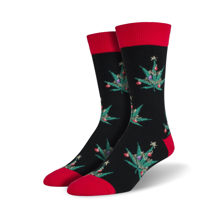 Pair of crew socks; black with red cuffs; features a repeating pattern of marijuana leaf Christmas trees with colorful ornaments. }}