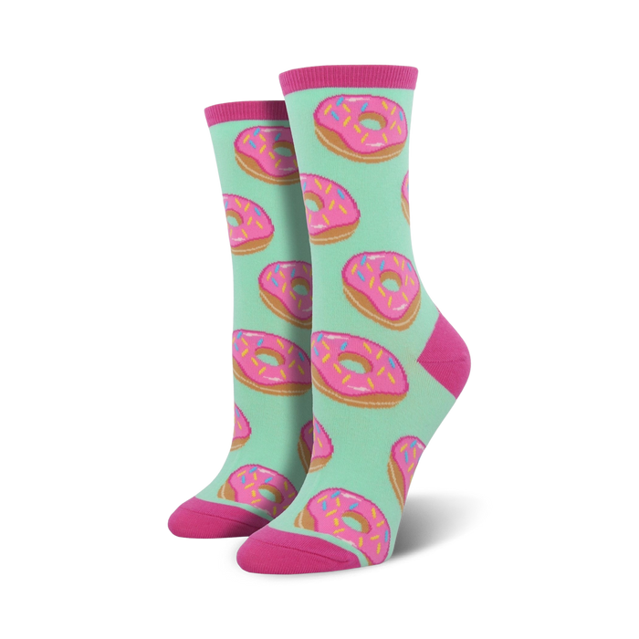 A pair of women's crew socks with a mint green background and a repeating pattern of pink donuts with colorful sprinkles. }}