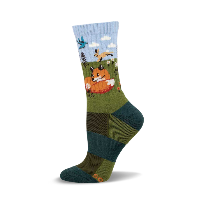 Crew socks in teal, olive, and light blue, featuring a whimsical illustration of a fox, hare, and bird in a forest scene. }}