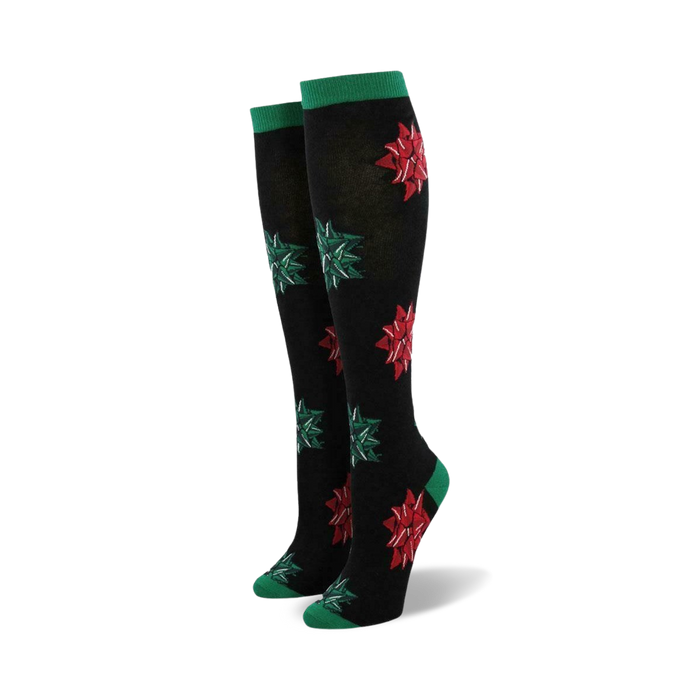 Pair of women's knee-high socks. Black with red and green Christmas bows. Green cuffs.