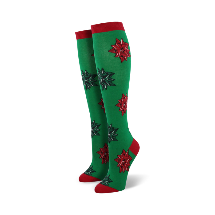 Pair of women's green knee-high socks with red and green Christmas bows. Red cuffs.