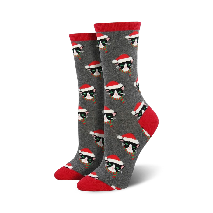 Pair of women's crew socks; gray background with repeating pattern of black cats wearing Santa hats and scarves. }}