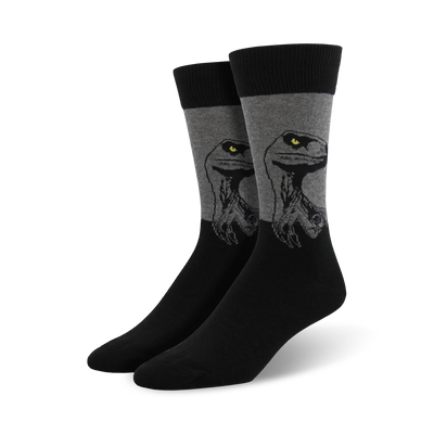 A pair of men's crew socks in black and gray. The socks feature a graphic design of a raptor's head, with yellow eyes.