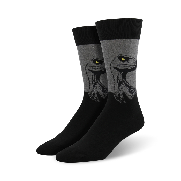 A pair of men's crew socks in black and gray. The socks feature a graphic design of a raptor's head, with yellow eyes. }}