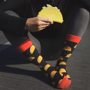 Lifestyle photo: Person wearing the taco socks and holding a real taco.