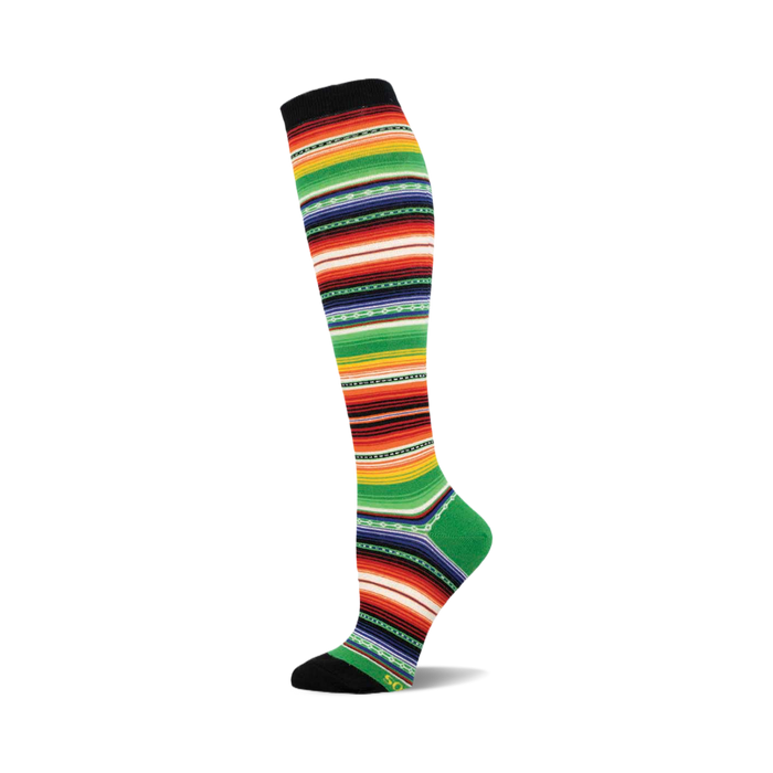 Knee-high sock in a serape pattern. The colors are predominantly green, red, orange, and black stripes with smaller yellow and blue details. }}