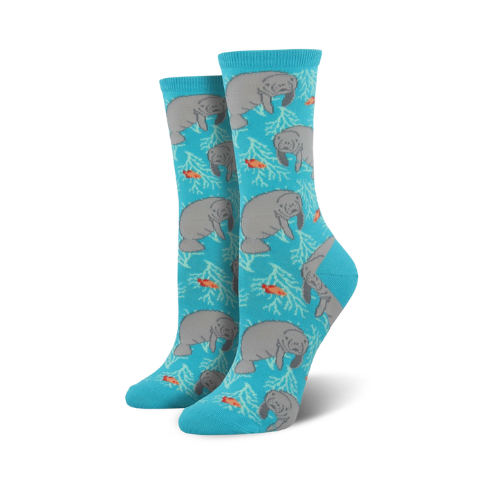 Pair of teal crew socks featuring a repeating pattern of gray manatees, orange fish, and white coral. }}