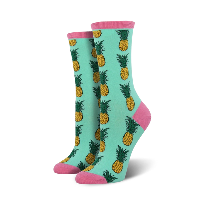mint green socks featuring a pattern of yellow pineapples with green leaves and pink toes and heels.    
