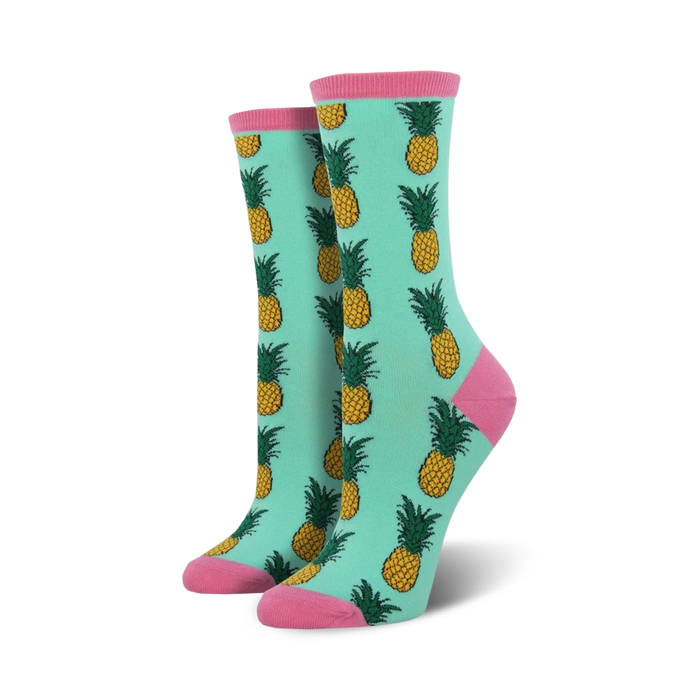 Pair of women's crew socks in teal with a repeating pineapple pattern.  Pink accents at the top and bottom.