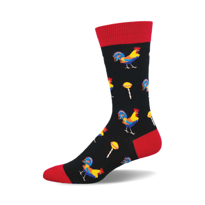 Black crew socks with a red cuff featuring colorful roosters and yellow lollipops on a repeating pattern.