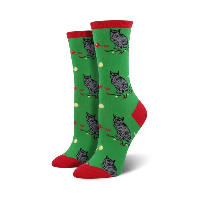 Crew socks in green with a red cuff, featuring a repeating pattern of grey cats and red berries on a green background. }}