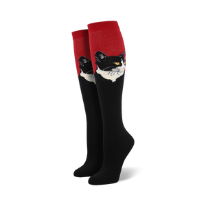 Close-up view of a pair of red and black knee-high socks with a black and white cat portrait.