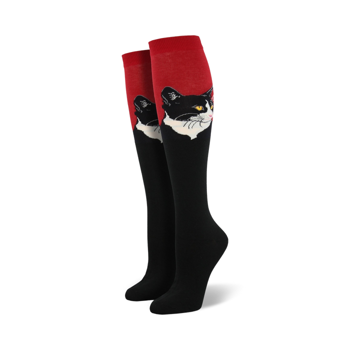 Close-up view of a pair of red and black knee-high socks with a black and white cat portrait.