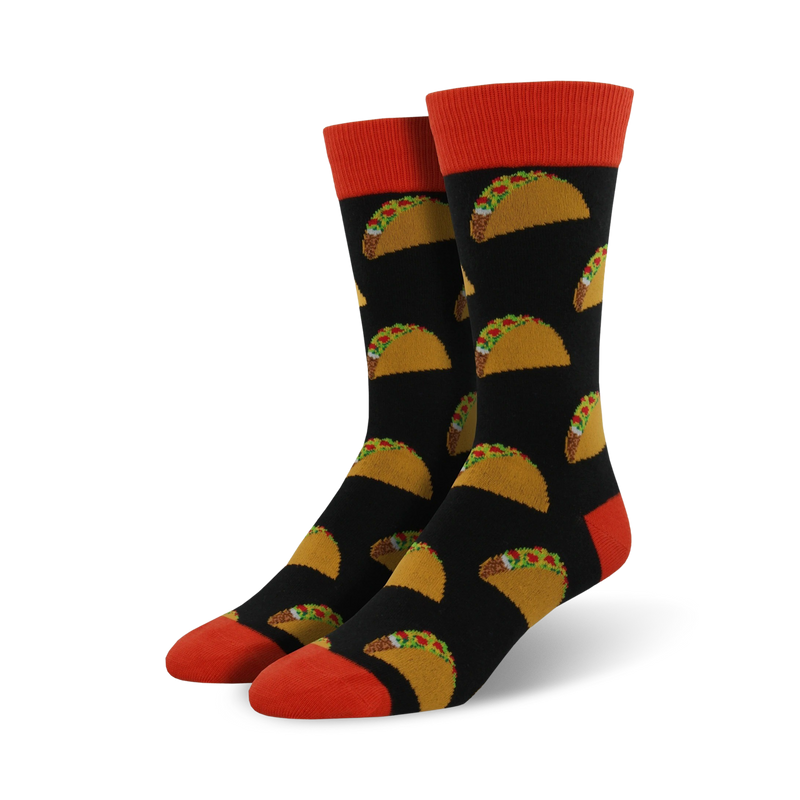 Pair of black crew socks with a repeating pattern of yellow tacos and green toppings. The socks have orange cuffs.