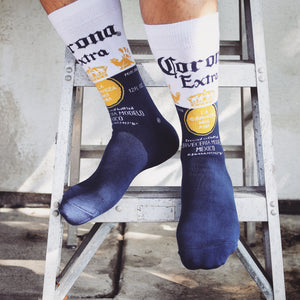 A person is standing on a step ladder wearing socks with a Corona beer design. The socks are blue with white and yellow accents and the Corona logo.