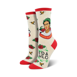 Cream crew socks with a Frida Kahlo portrait, red roses, hummingbirds, and 'Viva La Vida' text. Red and green accents.