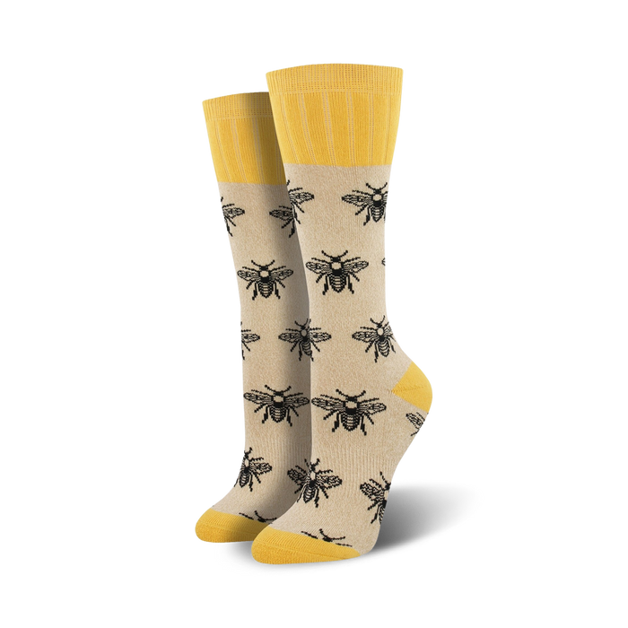 Pair of beige crew socks with black bee illustrations and yellow cuffs. }}