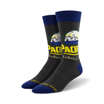 Pair of crew socks in grey with a Pacifico beer-inspired design featuring yellow and blue text and mountain imagery.
