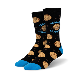 Lifestyle shot of Tough Cookie socks on a person's feet; the socks are black with blue cuffs and chocolate chip cookie designs.